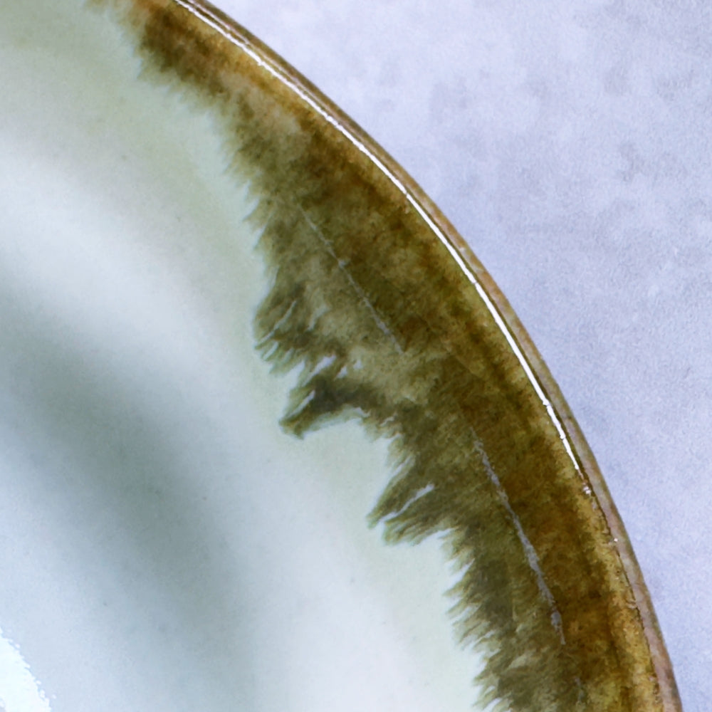 Close-up of a Japanese ceramic matcha bowl rim with a brown rim on a white background